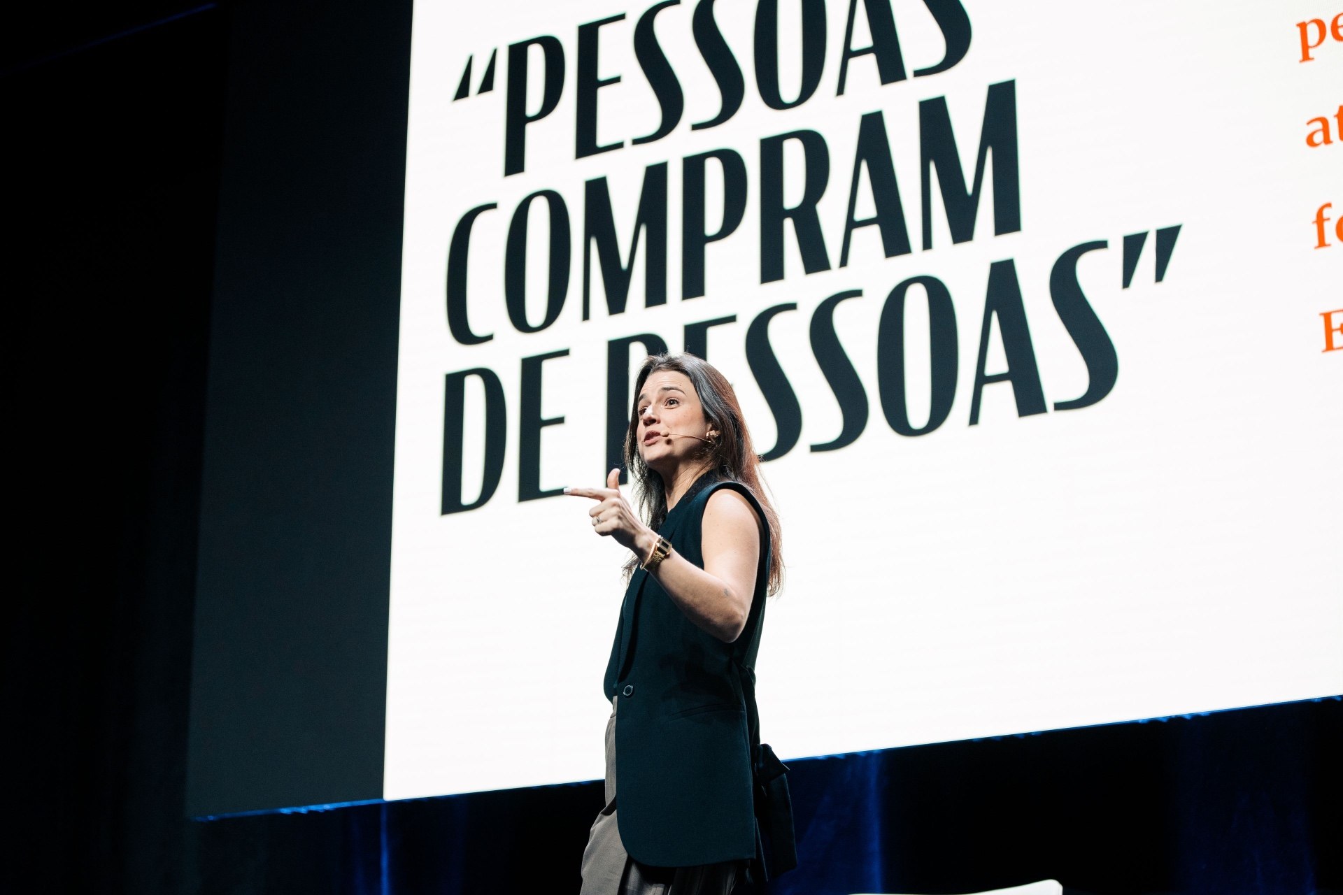 Beatriz apresenta a frase “Pessoas compram de pessoas” durante sua fala.