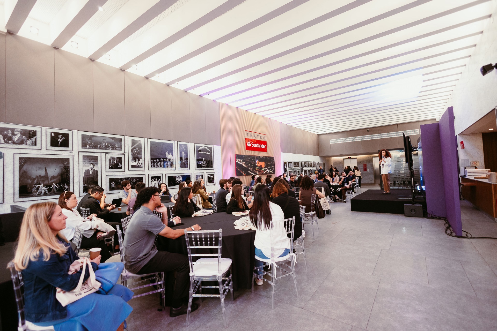 Vista geral da sala com a plateia acompanhando a apresentação